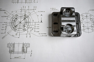 Precision-machined metal component lying on its technical drawing, showcasing accuracy and...