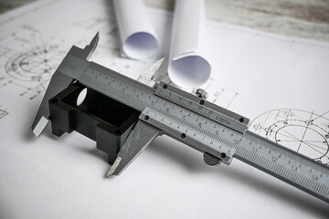 Caliper measuring a plastic component on top of technical drawing, engineering and quality control...