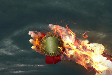 Woman holding gold medal in her flaming hand against darkened sky, closeup