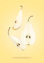 Fresh sliced pears in air on yellow background