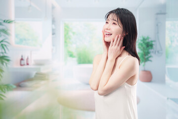 家でスキンケアをする若い女性