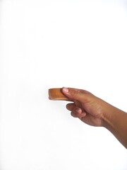   The image shows a hand holding a little round wooden bowl with a smooth surface. The plain white background emphasizes the natural texture and grain patterns of the wood, making the bowl the central