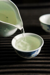 Experience the elegant and calming art of tea pouring in traditional Chinese teacups today