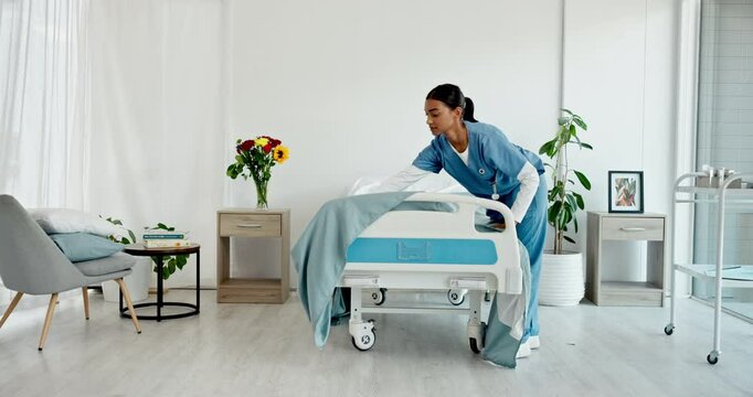 Healthcare, nurse and preparing of hospital room, woman and making of bed, service and fresh blanket. Serious, medical professional and cleaning of nursing home, caregiver and person with sheets