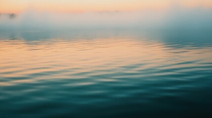 Obraz premium A serene water scene at sunset, with mist rising and soft colors reflecting on the surface.