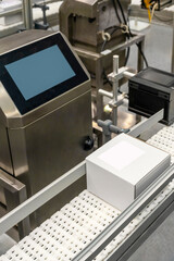 .Vertical photo white carton boxes on the production lines of packing and labelling machine. 