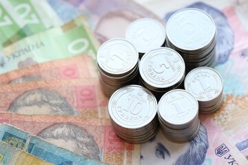 Few stacks of ukrainian money coins lies on old hryvnia banknotes