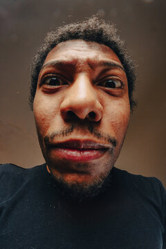 Young man making funny face with fisheye lens effect