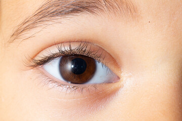 Close-up of brown eye showing eyelashes and eyebrow of young child