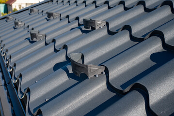 Snow guard installed on a metal roof with corrugated tiles