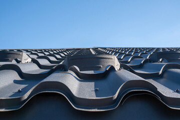 Metal snow stopper mounted on a corrugated tile roof