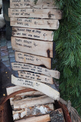 Christmas market menu written on the piece of wood  with green branches behind in Latvia