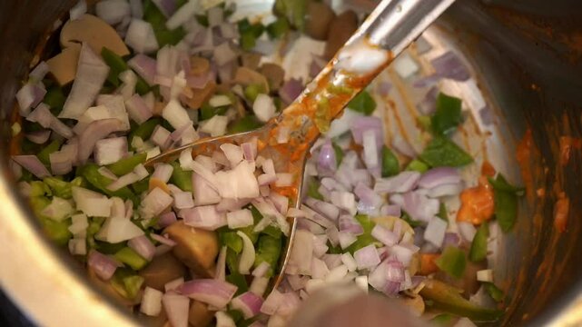 mixing traditional street food known as bhel puri food item in Indian chat, Hand of man making in a large metal bowl with puffed rice, vegetables and spices.