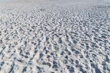 Sandy beach with footprints. Natural background.