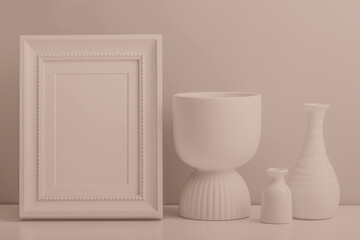 Ceramic vases and photo frame on the table. Tinted image with copy space.