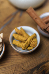 Fresh Turmeric Roots and Cinnamon Sticks beautifully arranged on Rustic Wooden Surface