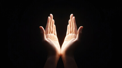 Two open hands illuminated against a dark background, symbolizing hope and mindfulness.