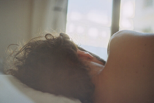 Close-up Rear view of a shirtless Man sleeping in a bed