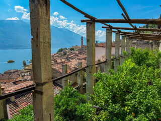 Interior of castle Limonaia del Castel with scenic view of picturesque lakeside town Limone Sul Garda, Lombardy, Northern Italy. Tranquil atmosphere on Garda Lake surrounded by majestic mountains