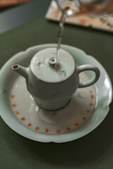 A beautifully designed teapot pouring water onto a saucer, showcasing fine craftsmanship