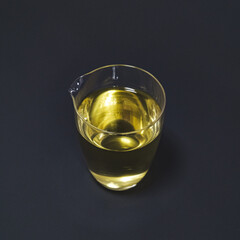 A Transparent Jug Filled with a Beautiful Golden Liquid Placed on a Dark Surface Background