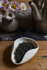 An Elegant Tea Setup Featuring Loose Tea Leaves Beautifully Arranged with Fresh Flowers