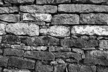 Obraz premium Rustikale Trockenmauer bedeckt mit grünem Efeu. Natürliche Textur und Struktur, ideal als Hintergrund für Präsentationen, Werbung und Banner. Schöne Verbindung von Natur und Architektur