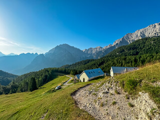 Rustic cottage on alpine pasture on Somdogna alp with scenic view of majestic mountains peaks...