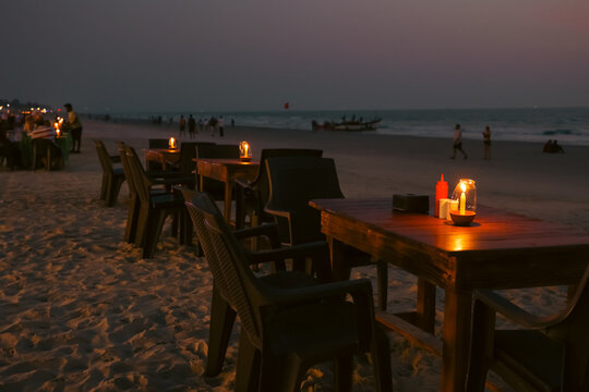 Night view of Beach restaurant shacks and sun beds in north Goa India. Party at sunset in GOA India. Tropical sunny beach party at Sunset with Sun umbrellas loung