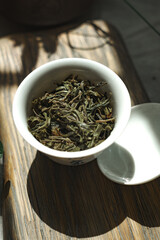 A beautiful arrangement of Organic Green Tea Leaves placed in a simple White Bowl