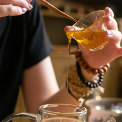 Artisan Brewing The Art of Pouring Honey into a Beautiful Glass Teapot for Enjoyment