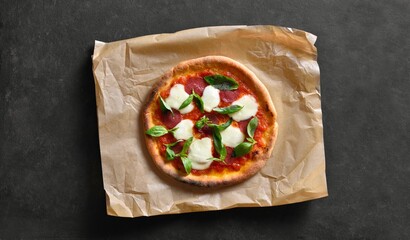 Pizza with mozzarella, pepperoni, tomato sauce and basil