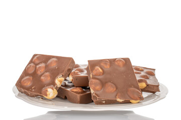 One bar of dark chocolate with hazelnuts, close-up, isolated on a white background.