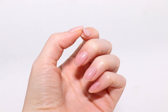 Woman hand with gel nail polish peeling off. Bad manicure.