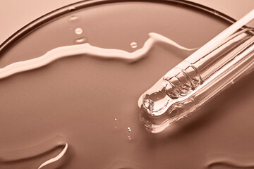 Pipette with sample of cosmetic product in petri dish in mocha mousse color