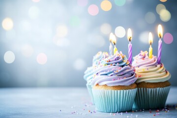 Cupcake with a lit candle, perfect for birthday celebrations. Birthday candle on a cup cake on table. Copy space for text on blurred lights bokeh background. Perfect for a Party or celebration card.