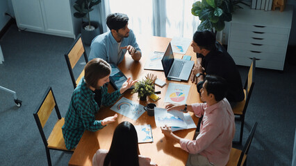 Skilled project manager walking at table while colleague brainstorm idea. Business team working together to plan marketing strategy while looking at data analysis or financial statistic. Convocation.