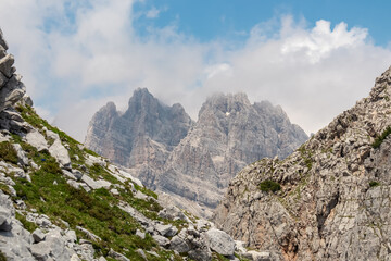 Panoramic view of cloud covered rocky rugged mountain peaks of majestic Brenta Dolomites, Trentino, Italy. Wanderlust in alpine wilderness. Hiking in pristine Italian Alps in summer. Peace tranquility