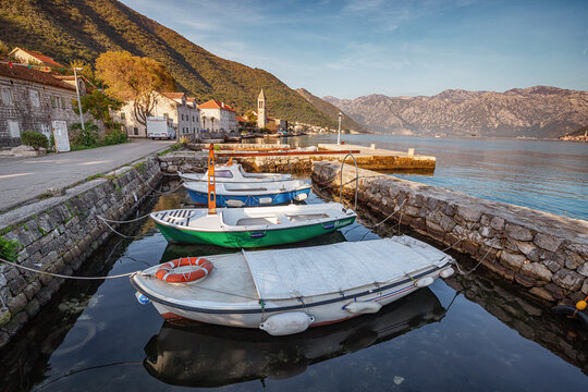 25 October 2024, Donji Stoliv, Montenegro: Tranquil scene of white boats moored in the serene waters of Kotor Bay as dusk settles over the charming coastal village