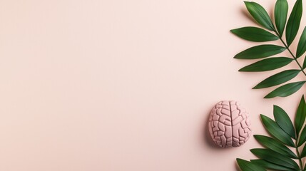 Creative Flat Lay of a Pink Brain Model with Green Leaves on a Soft Peach Background for Educational or Medical Use