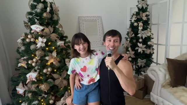 pai e filha cantando com microfone no natal 