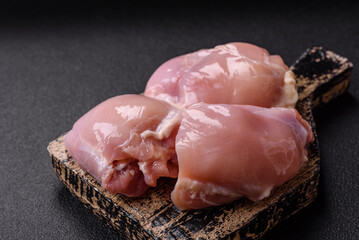 Fresh raw chicken thigh fillets with salt, spices and herbs