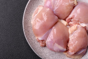 Fresh raw chicken thigh fillets with salt, spices and herbs