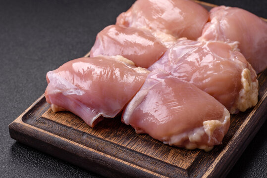 Fresh raw chicken thigh fillets with salt, spices and herbs