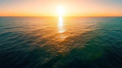 Obraz premium Serene Sunset Over Calm Ocean Waters with Gentle Waves and Golden Sky Reflection