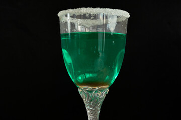 Green liquor cocktail with sugared rim on black background celebrating St. Patrick’s Day