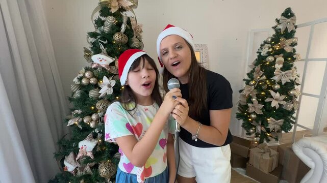 m&atilde;e e filha cantam com microfone no natal 