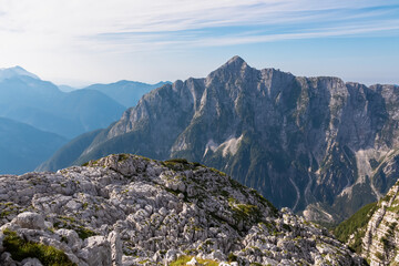 Obraz premium Scenic view of pristine rugged mountain peaks of Kanin massif, Julian Alps, Italy, Europe. Wild hiking trail along majestic ridges in Triglav National Park. Wanderlust alpine wilderness in summer. Awe