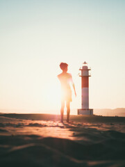 Atardecer con niño observando el faro de El Fangar, en el Delta del Ebro, en España