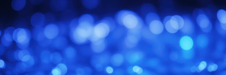 Magical blue bokeh lights create a serene atmosphere in a dimly lit space during evening hours